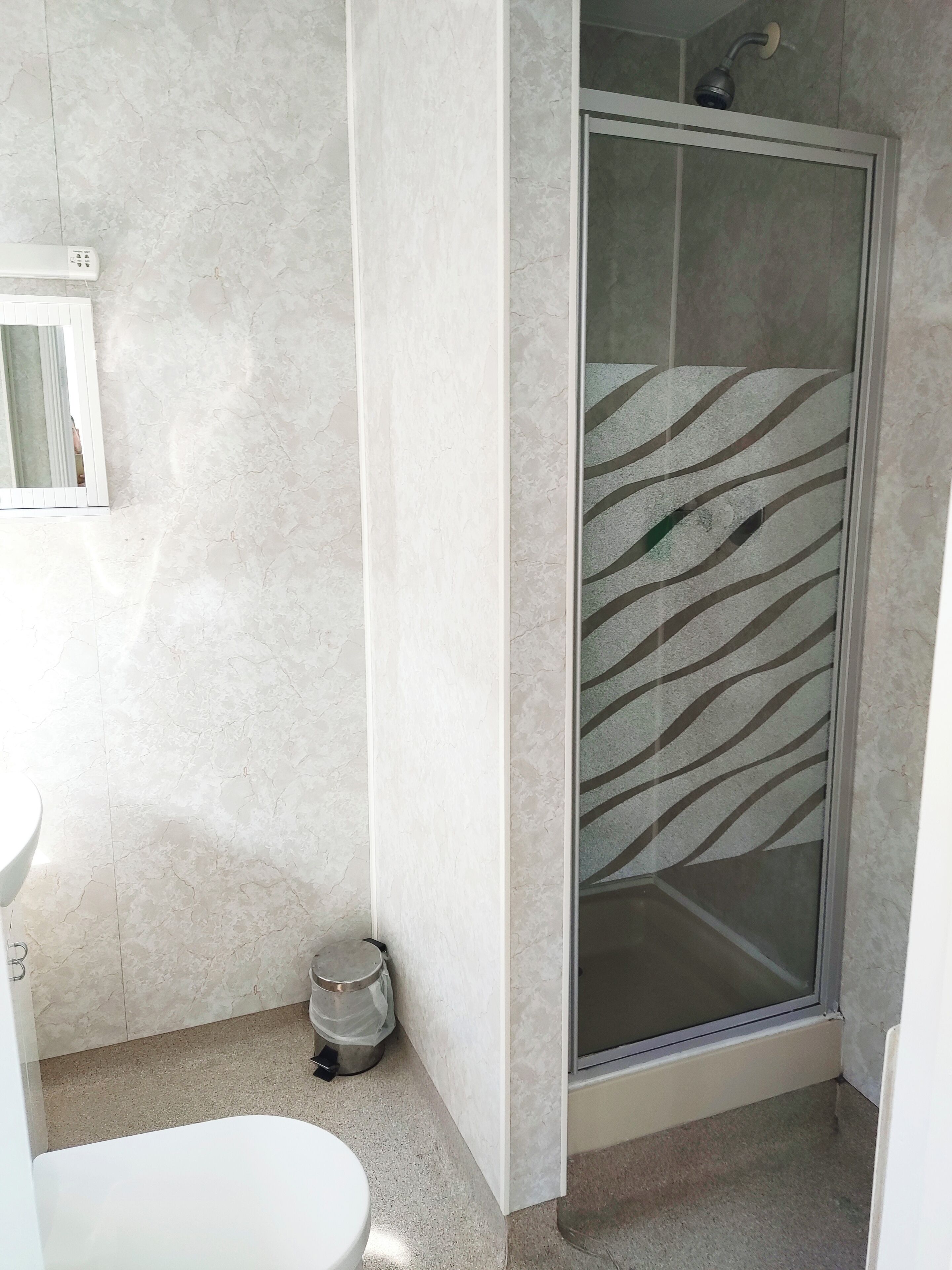 Ein Badezimmer mit Dusche, Toilette und Waschbecken.