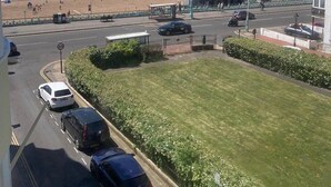 A coastal view with a beach, pier, and parked cars. - Central Wave Brighton  (Brighton)