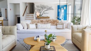 A modern living room with a sofa, coffee table, and potted plants. - Luxe Lakefront Retreat★Sauna★Media Rm★Kayaks-SUPs★Bikes★Steps to BikePath★Pet OK (Harwich)