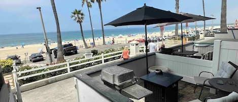 Relax on the patio with a grill and umbrella, taking in the view of the beach and surrounding palm trees.