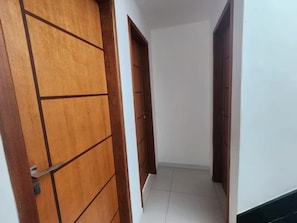A hallway with wooden doors and white walls.