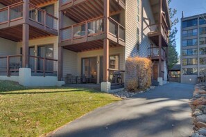 A multi-story building with balconies, a paved driveway, and a grassy area. - Lakefront Condo in Kings Beach- #43 (Kings Beach)