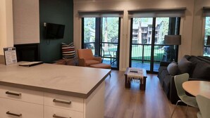A modern kitchen with a large island, a dining area with a table and chairs, and a seating area with a sofa and armchairs. - Lakefront Condo in Kings Beach-#41 (Kings Beach)