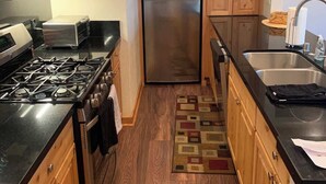 A kitchen with wooden cabinets, a stainless steel refrigerator, a gas stove, a microwave, and a sink. - Lakefront Condo in Kings Beach-#33 (Kings Beach)