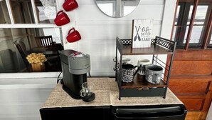 A compact kitchen with a coffee maker, a small refrigerator, and a coffee station with red cups. - Charming, lake-front, 2-bedroom cabin with AC, WiFi in superb Derby (Derby)