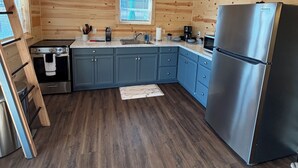 Una cocina moderna con paredes de madera, un refrigerador de acero inoxidable y un horno empotrado.
