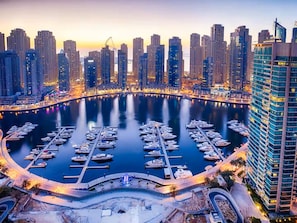 A marina with multiple docks surrounded by high-rise buildings.
