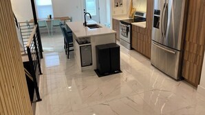 Una cucina moderna con isola centrale, elettrodomestici in acciaio inossidabile e mobili in legno.