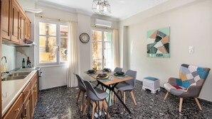 Une cuisine moderne avec un coin repas, des plans de travail en granit et une œuvre d’art murale aux motifs géométriques.