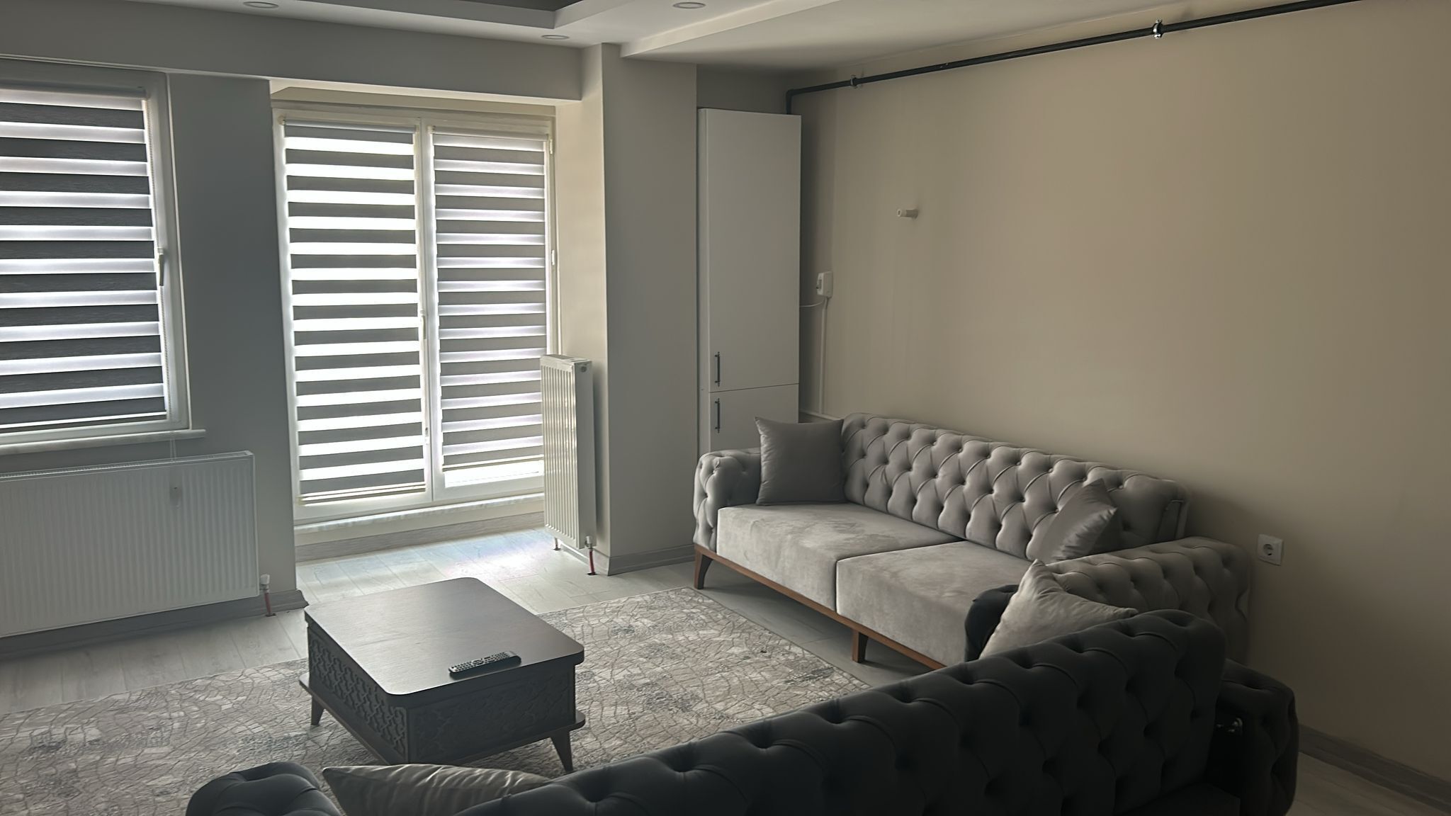 A modern living room with a grey sofa, a matching armchair, and a small coffee table.