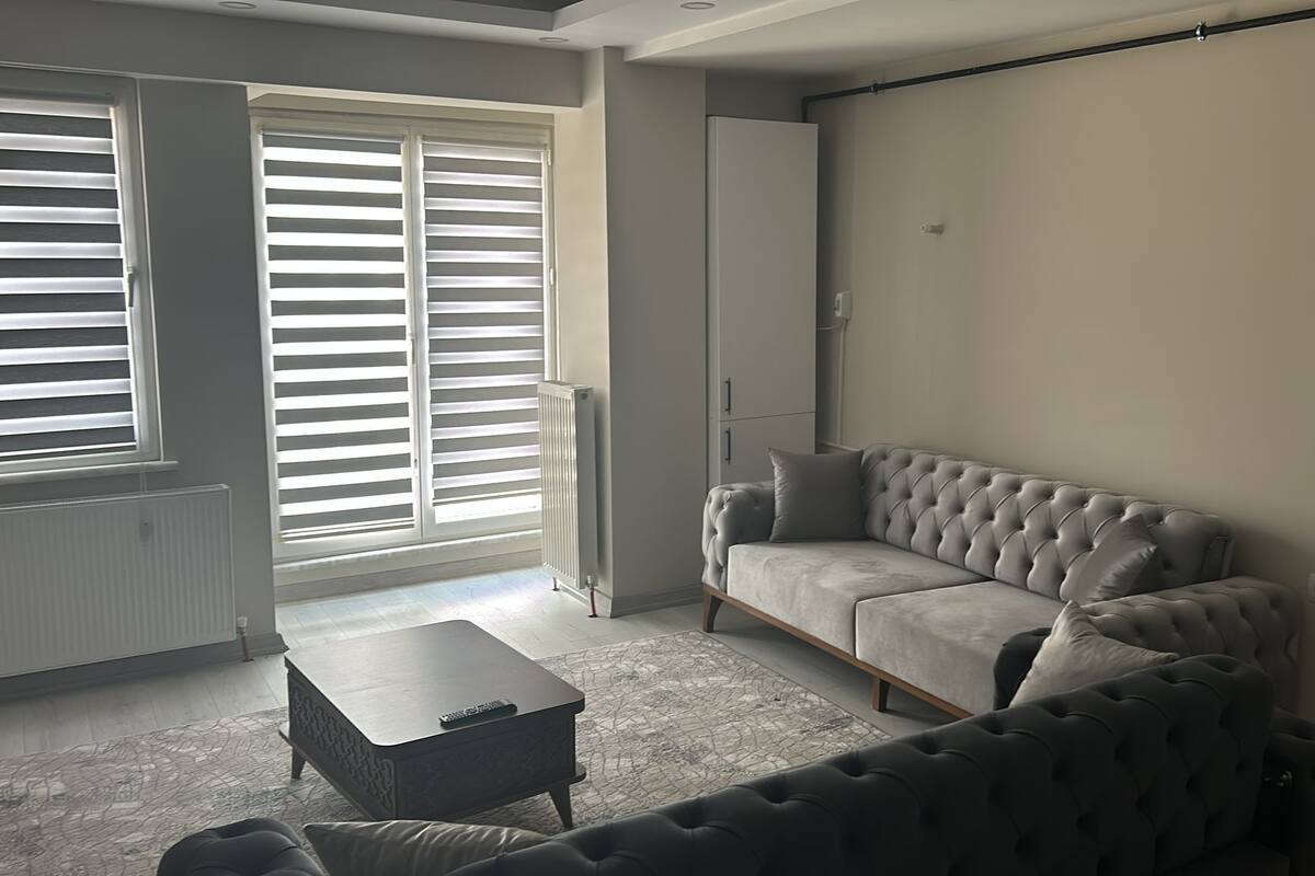 A modern living room with a grey sofa, a matching armchair, and a small coffee table.