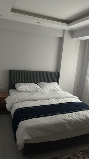 A modern bedroom with a bed, a headboard, and a nightstand. - Anka Butik Hotels (Istanbul)
