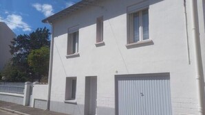 A two-story building with a garage door and two windows on the upper floor. - Very quiet family home a stone's throw from the town center. (Perpignan)
