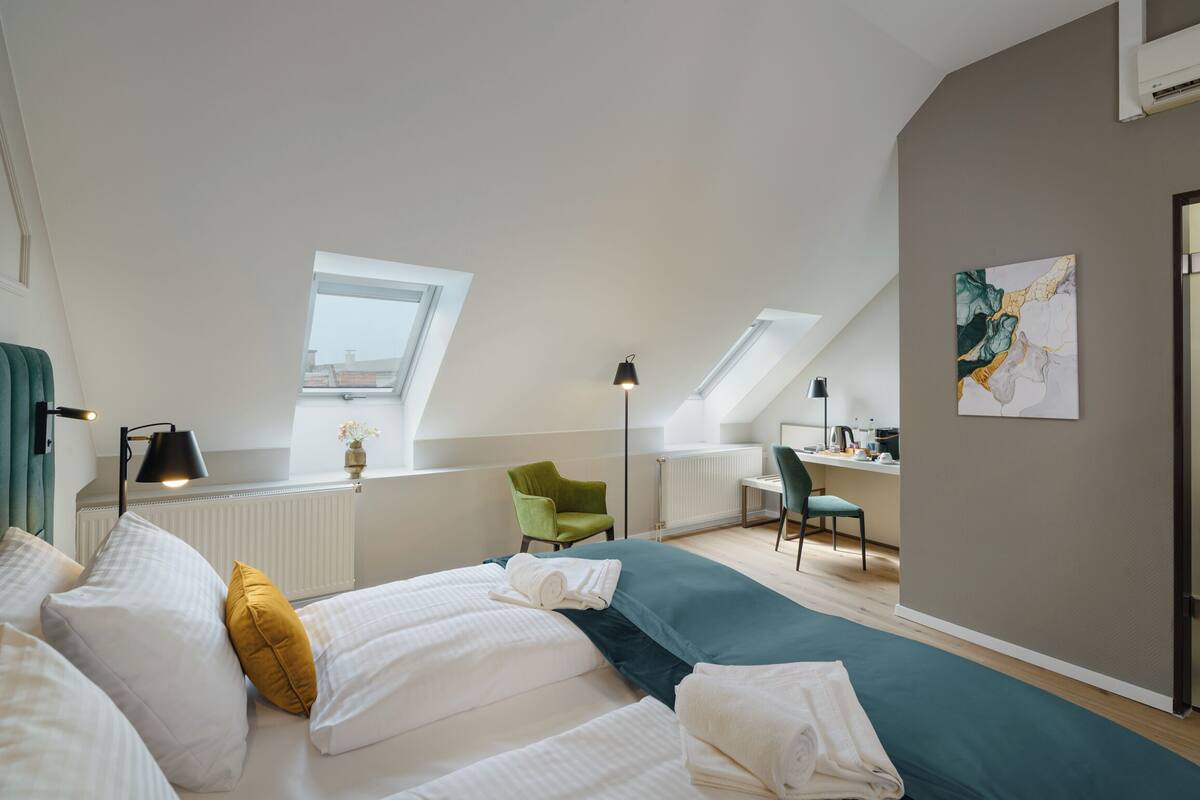 A modern bedroom with a skylight, a desk, and a chair.