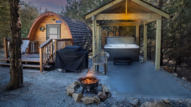 Una cabaña acogedora con jacuzzi, terraza y una zona para fogatas.