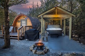Una cabaña acogedora con jacuzzi, terraza y una zona para fogatas.