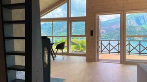 A spacious room with large windows offering a view of mountains and a lake. - FjordCabin Preikestolen (Rogaland)
