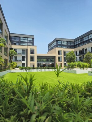 A modern building with a central courtyard, surrounded by greenery and featuring multiple balconies. - premier luxury apartment (Accra)