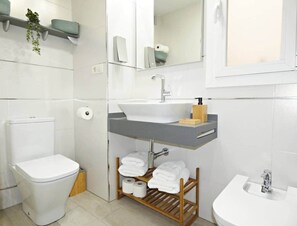 Regadera, secadora de cabello, bidet, papel de baño 