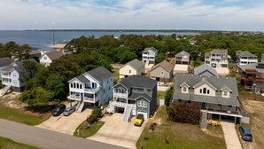 Un quartier résidentiel avec des maisons, une allée et un plan d’eau en arrière-plan.