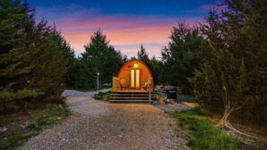 Een knus houten vakantiehuisje met een veranda, omringd door dicht bos.