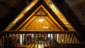 An attic room with a wooden ceiling and a sloped roof. - Serene cabin with dock/swim platform in charming Speedwell (Speedwell)