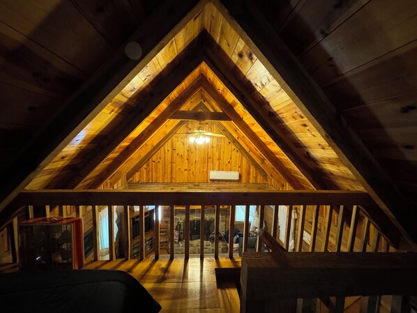 Une chambre mansardée avec un plafond en bois et un toit en pente.