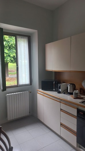 Enjoy a kitchen with a window view, featuring a radiator, microwave, kettle, and coffee maker.