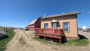A single-story house with a red porch and a small attached garage. - Farmhouse Studio just minutes from uptown. (Butte)
