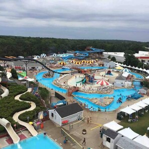 A water park with multiple slides and pools, surrounded by tents and trees. - Charming 4-bedroom Onset Home (Wareham)