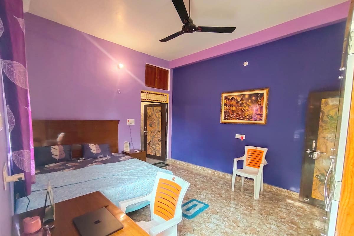 A room with a bed, a desk, a chair, a ceiling fan, and a door with a decorative design.