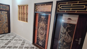 Un pasillo con suelo estampado, puertas decorativas y un felpudo.