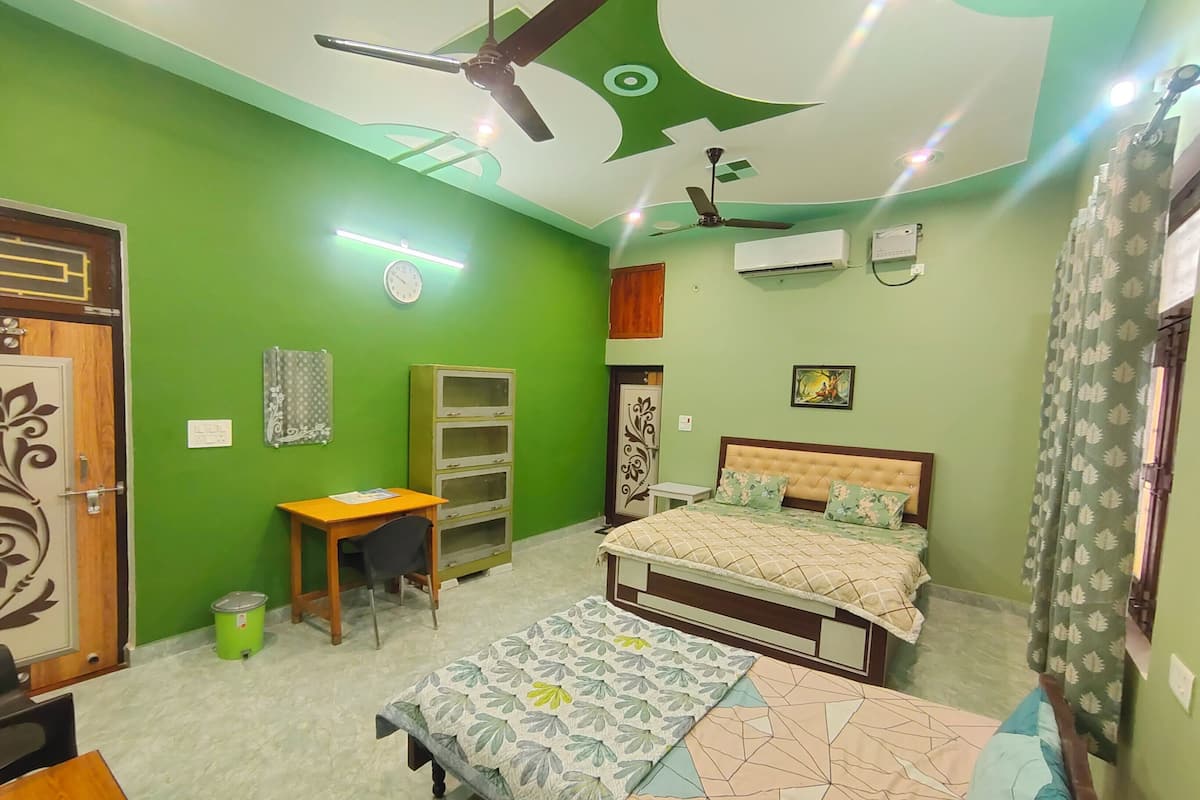 A room with a bed, a desk, a chair, a wardrobe, and a ceiling fan.