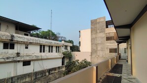 Un pasillo con piso estampado, edificios adyacentes y una antena visible.