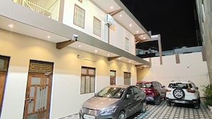 Un edificio de varios pisos con una zona de estacionamiento.