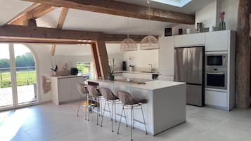 Una cocina moderna con una isla grande, electrodomésticos integrados y un tragaluz.