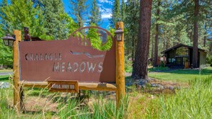 A sign for Graeagle Meadows with a wooden post and metal plaque, surrounded by trees and grass. - Vacation retreat for golf and enthusiasts and families alike! (Graeagle)