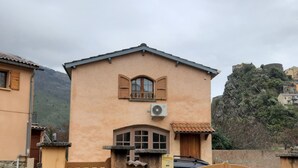 A building with a gated entrance, a small balcony, and a window with shutters. - Detached house in a property at the entrance to the Restonica valley (Corte)