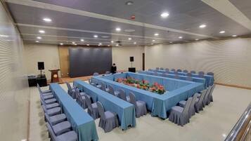 A conference room with a long table, chairs, and a podium.