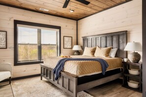 Relax in this inviting room with a large bed, bedside tables, and a comfortable chair by the window.