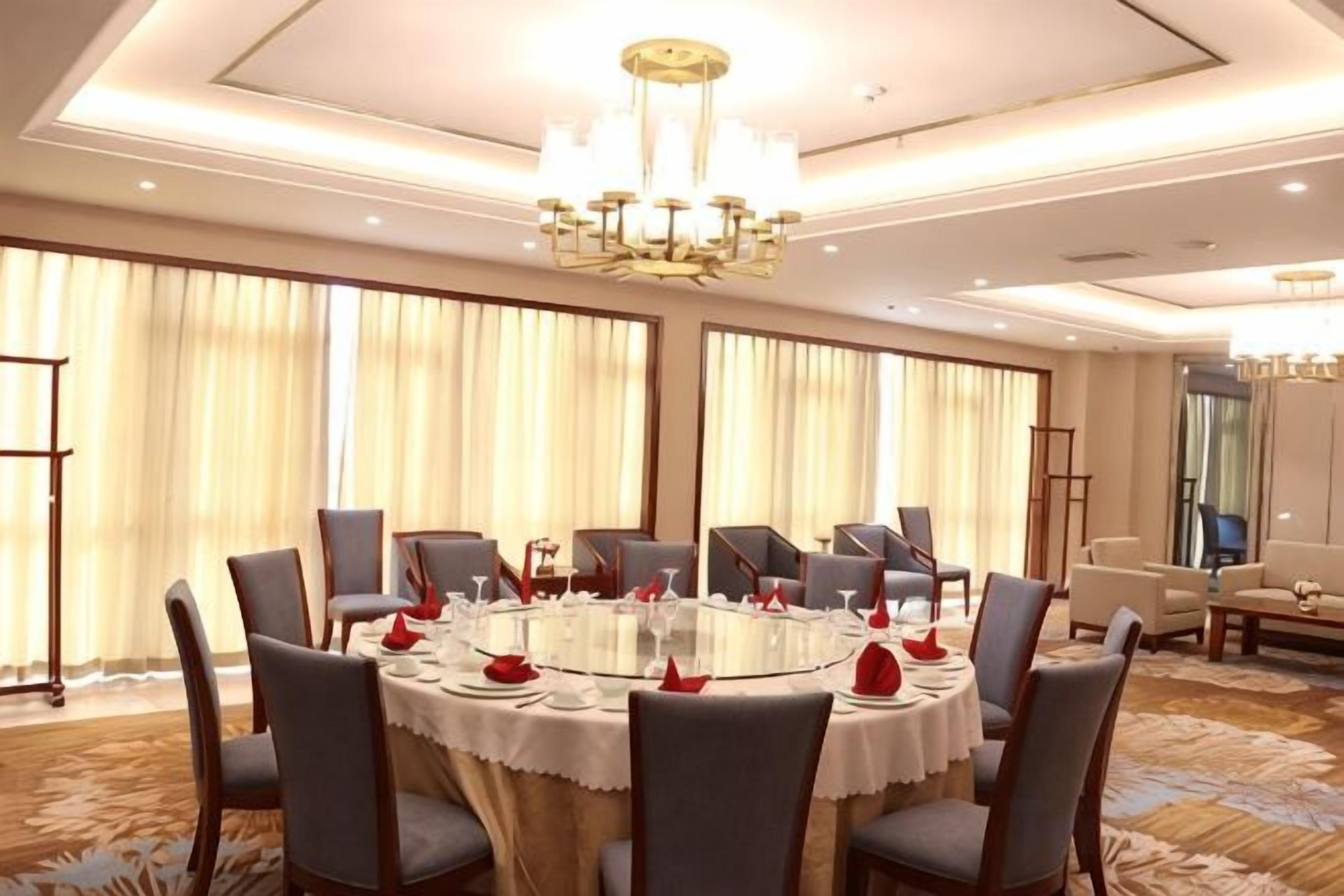 Un salón de conferencias con una mesa redonda, sillas y una araña.