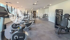Ein Fitnessstudio mit Laufbändern, Crosstrainern und Gewichten.