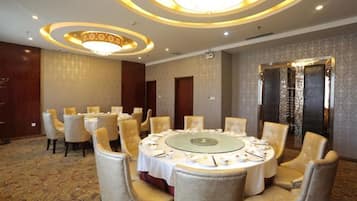 A conference room with a round table, chairs, and a chandelier.