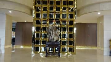 A lobby with a central seating area, a patterned wall, and a polished floor.