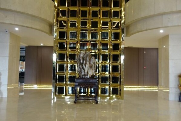 A lobby with a central seating area, a patterned wall, and a polished floor.