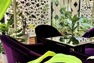 Una habitación con una mesa, sillas moradas y varias plantas.