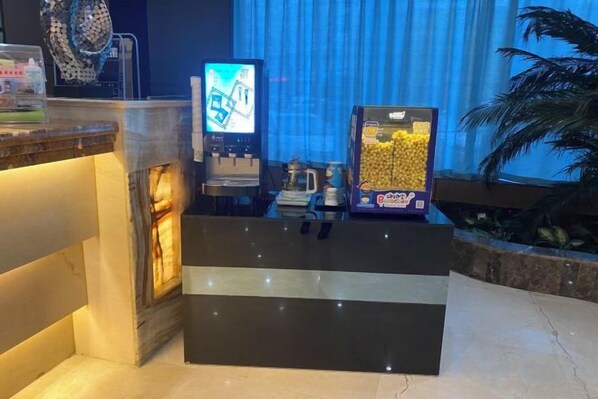 A reception area with a counter, a television, and a slot machine. - Rongda International Hotel (Yulin)