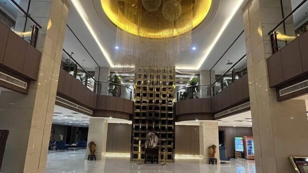 A spacious lobby with a central decorative element, glass railings, and a polished floor. - Rongda International Hotel (Yulin)