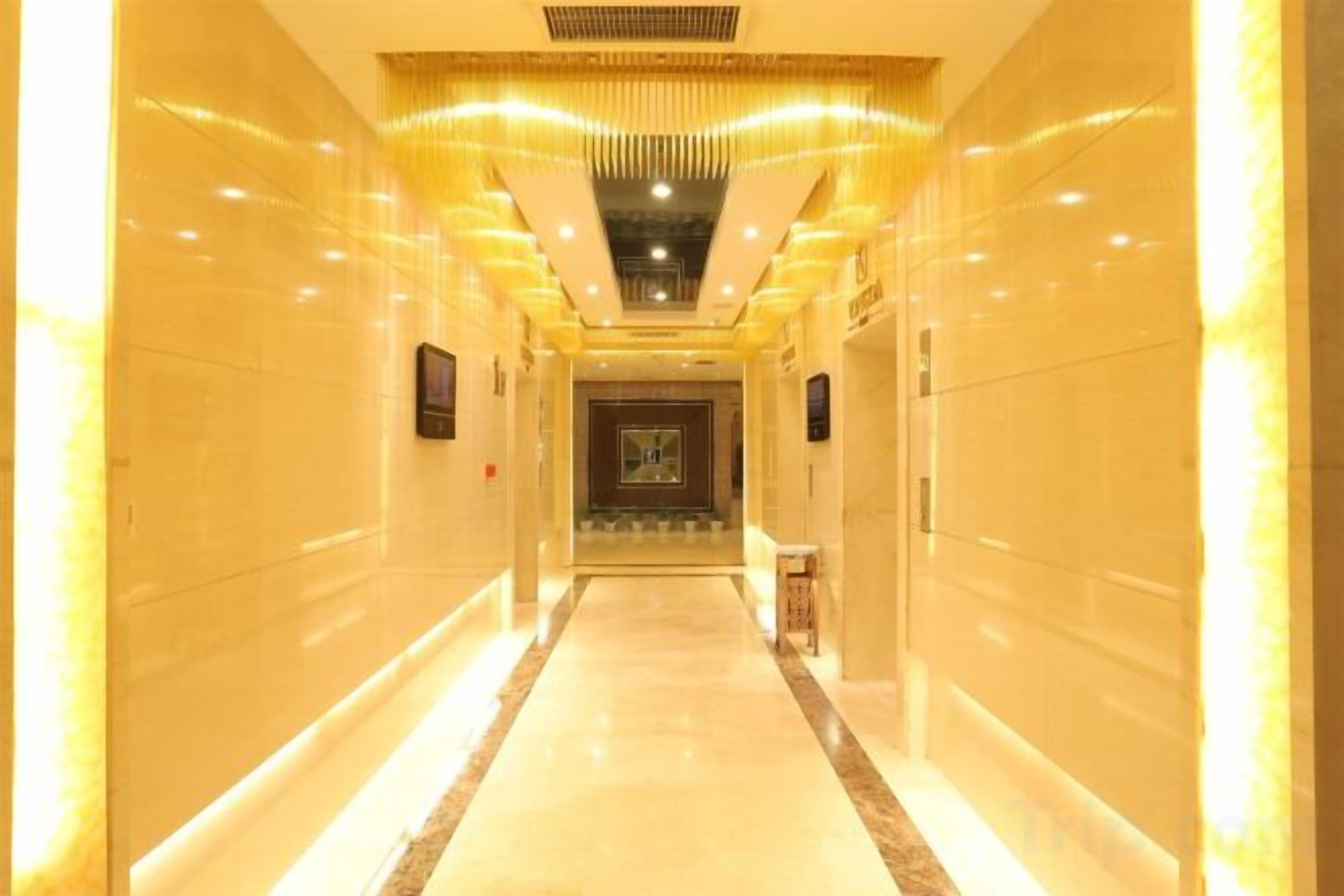 A long, well-lit hallway with a marble floor and a central light fixture.