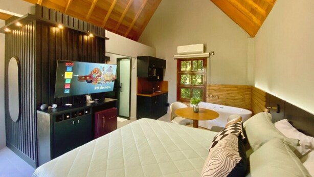 Une chambre confortable avec un lit, une télévision, un bureau et une fenêtre.